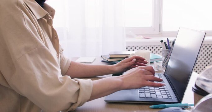 Business office. Online work. Unrecognizable woman entrepreneur typing laptop at desk searching information at professional workplace.