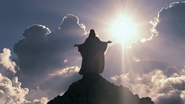 Jesus silhouette on a hilltop, surrounded by clouds and the light. 