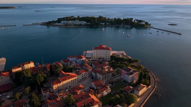 Porec harbor and Sveti Nikola island viewed from above the old town peninsula at sunset, Istria, Croatia.