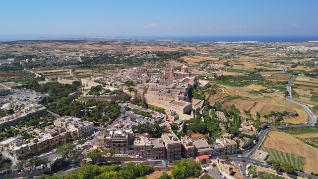 Mdina and Rabat in Malta with St Paul's Cathedral, fortified medieval old town, bastions and stone buildings surrounded by countryside, captured in an aerial panorama.