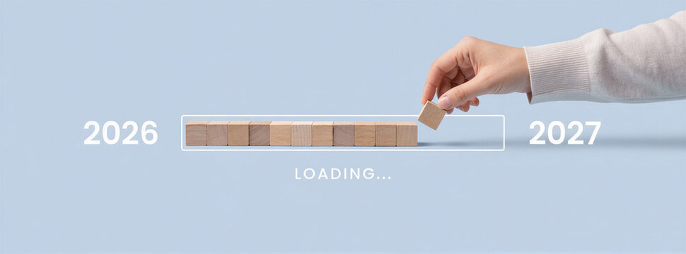 Hand completing wooden block loading bar from 2026 to 2027