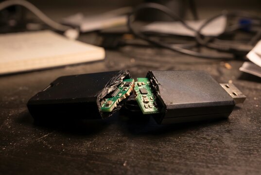 Macro close up of a snapped USB cryptocurrency hardware wallet exposing the broken circuit board