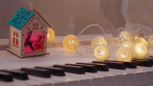 Cozy Christmas Toy House and Garland lights on Piano Keys 4K