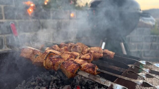BBQ. Grilling skewers of marinated meat creates a smoky aroma in an outdoor environment. Culinary exploration concept.