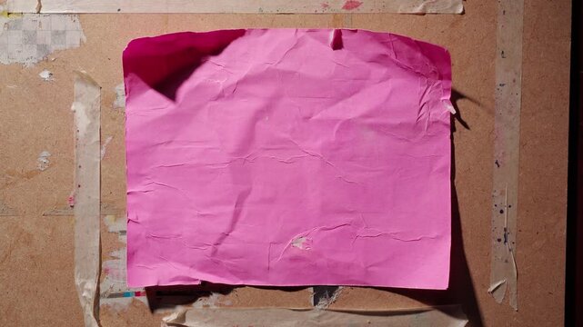 Old Peeling Pink Poster Texture on a Weathered Grunge Wall Fluttering in the Wind &ndash; Horizontal Composition Adaptable for Vertical Layouts