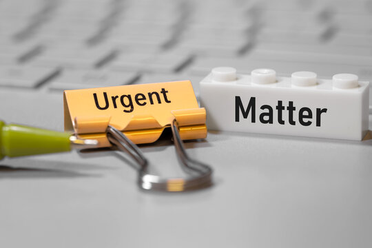 Urgent matter concept with binder clip and building block