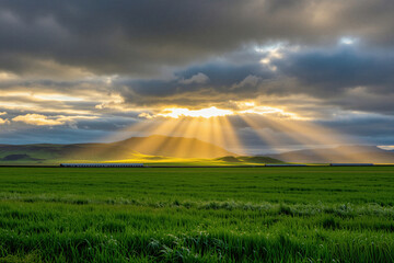Obraz premium Sunbeams shine through dark clouds over green Icelandic meadows, mountains. Golden light hits grass fields under cloudy sky at dawn. Beautiful rural landscape panorama shows dramatic weather,