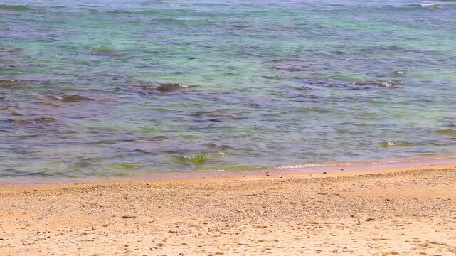 Sun turquoise blue clear water waves rocks Merlin Beach Thailand.