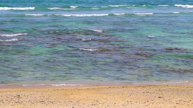 Sun turquoise blue clear water waves rocks Merlin Beach Thailand.