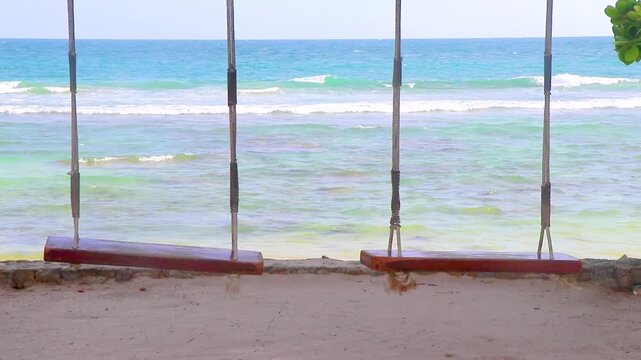 Sun turquoise blue clear water and swings Merlin Beach Thailand.