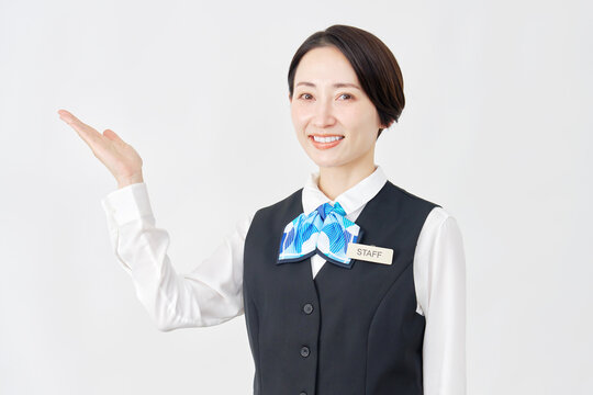 左側を手で指す女性スタッフ　受付嬢・銀行員　白背景