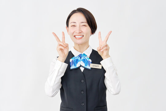 女性スタッフ　受付・バスガイド　ピースサイン　白背景