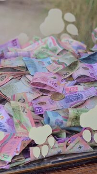 A collection of Mexican banknotes scattered in a box