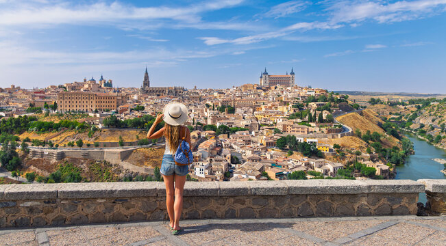 Woman tourist looking at Toledo cityscape in Spain, travel and freedom concept