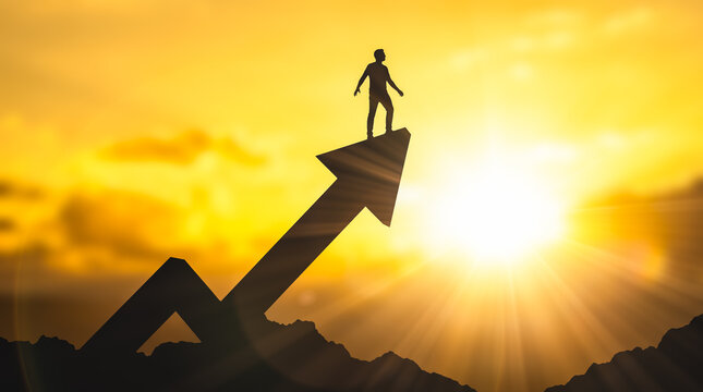 Businessman silhouette standing atop huge upward pointing arrow against bright golden sunrise symbolizing ultimate financial growth massive corporate success overcoming extreme business challenges