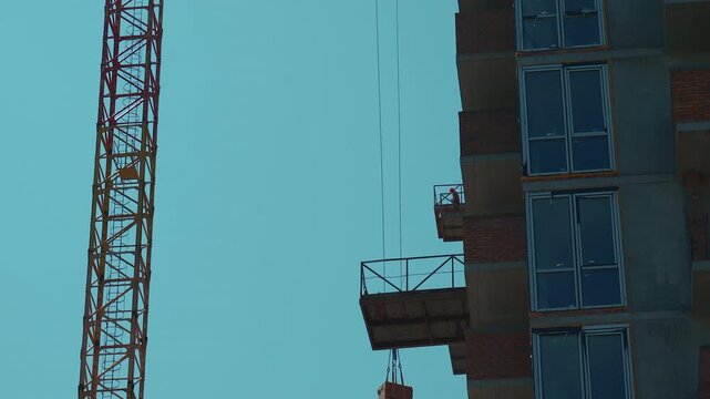 lifting bricks construction of new modern skyscraper or living building in city, real estate development 4k