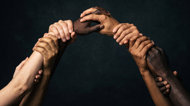 Diverse hands holding onto each other to form a bridge