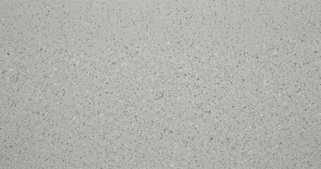 Fototapeta premium Light gray engineered quartz stone surface with fine speckled texture and subtle mineral flecks for interior