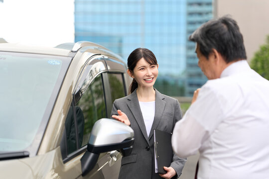 車の販売をするアジア人ビジネスウーマン