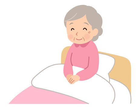 ベッドに座って微笑む高齢女性