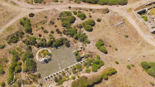 Balat, Turkey. Aerial drone view over the ancient Roman ruins of Miletus, revealing the Nymphaeum fountain, Capito Baths, and North Market amid sun-baked earth and scattered olive groves. Aerial View