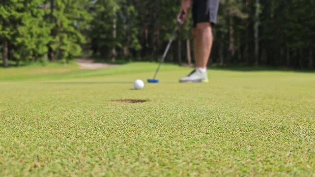 Putting practice at the golf course with a focus on making the perfect shot in the summer sun