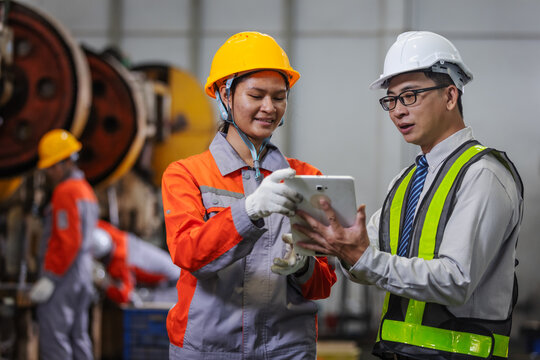 Manufacturing Engineer Reviewing Production Progress with Factory Technician on Shop Floor