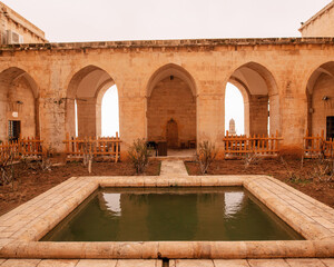 Fototapeta premium Historic Stone Courtyard with Ancient Arches and Traditional Middle Eastern Architecture , Historic Courtyard Architecture
