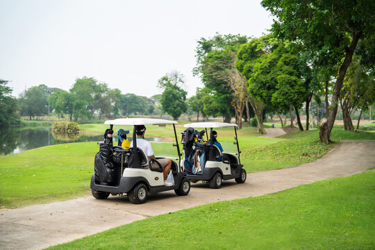 Group of golfers ride together in golf cart on scenic golf course.