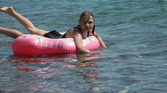 Girl swimming pool float ocean water playing summer activity leisure happy vacation time at beach for travel and family lifestyle concept footage