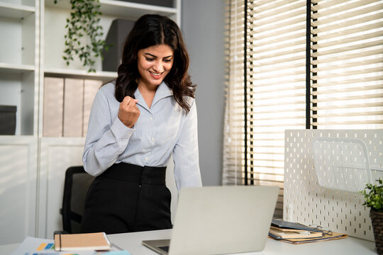 Indian young businesswoman checking sale order on computer in office. 