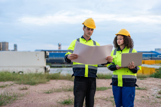 Caucasian male and Latina female engineer discuss project outdoors. 