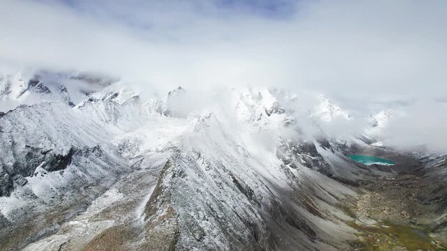 Drone view of beautiful snow covered mountains and peaceful lake, Ama Drime Snow Mountain and Dingjie Zongcuo Lake in Dingjie, Shigatse, Tibet, China. Travel concept 4k real time footage aerial view.