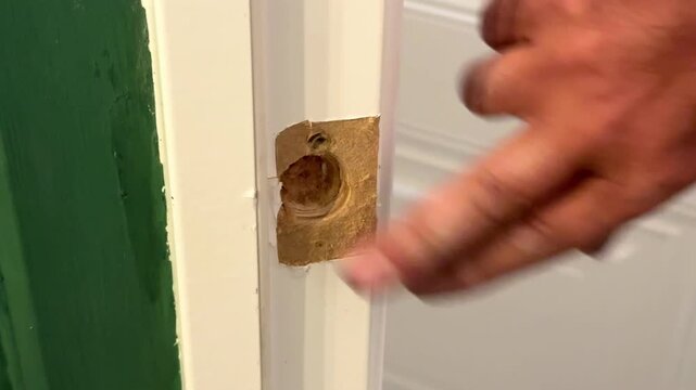 Men's hands repairing a door, door lock Apartment renovation, worker fixing white door, handyman at home, call a professional for repairs. High quality