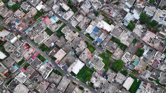 Drone flying forward over highly congested urban architecture and rooftops in India.