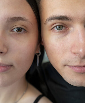 Close-up of a man and woman facing each other with expressive eyes, highlighting their unique features and emotions in a natural light setting.