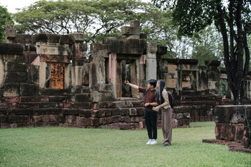 Asian Couple Taking Smartphone Selfie at Historic Temple During Cultural Travel Experience © อภิสิทธิ์ ปักเหนือ