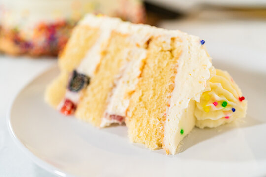 Side view of frosted berry cake slice on plate