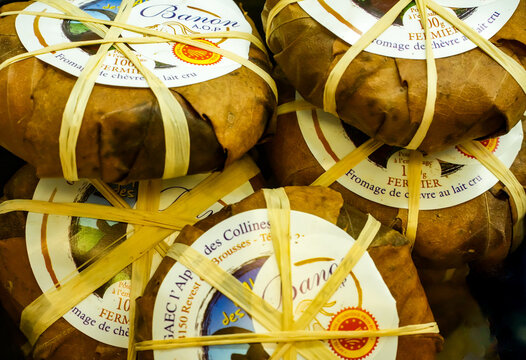 Several wheels of French Banon AOP, a famous raw-milk soft cheese made from goat&rsquo;s milk from Provence. The round cheese packages are traditionally wrapped in brown chestnut leaves