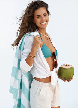 Beautiful young woman holding fresh coconut drink on tropical summer beach vacation