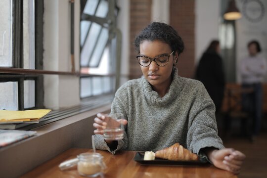 Young woman having a quiet breakfast in a cozy cafe