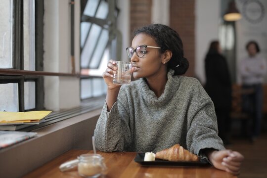 Thoughtful woman sitting alone in a coffee shop