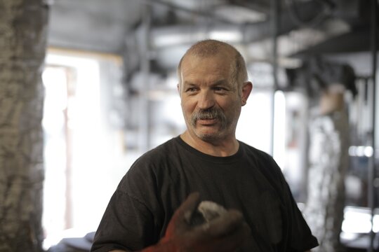 Experienced craftsman smiling in his workshop