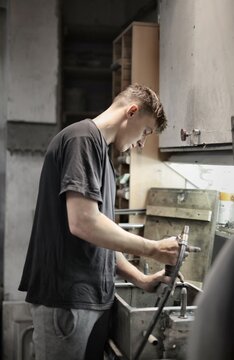 Young man concentrating on his task in a workshop