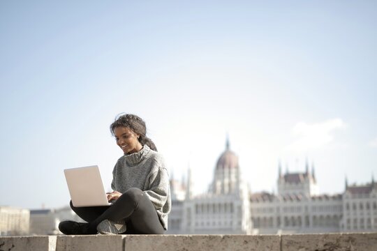 Young woman works on a laptop in Budapest