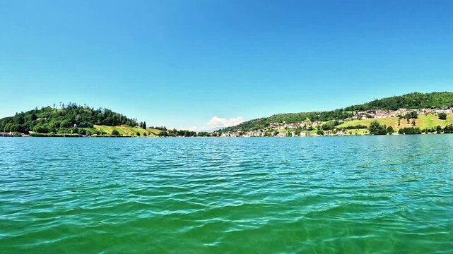 Slow-motion navigating POV in a lake surrounded by hills. Lake Serraia is located on the Pin&eacute; plateau, exactly in Baselga di Pin&eacute; in the province of Trento, Trentino
