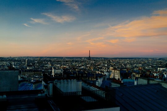 Paris city skyline with Eiffel Tower and rooftops at sunset