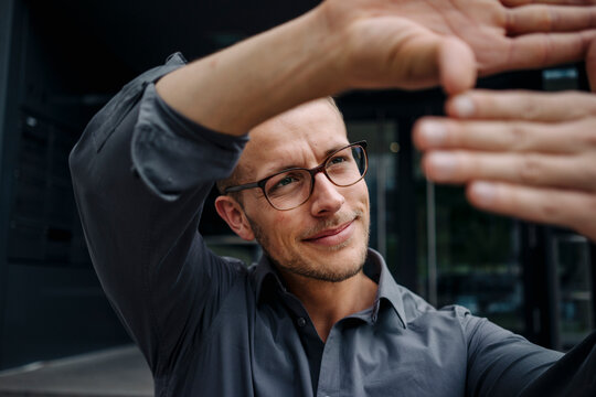 Portrait of smiling businessman making finger frame