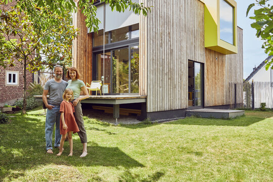 Family standing outside tiny house in yard