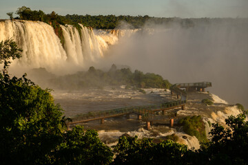 Naklejka premium Breathtaking iguazu falls create majestic nature landscape with mist covering wooden walkway